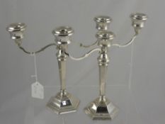 A pair of solid silver two branch candelabra, dated 1973, the candelabra having a centre screw top