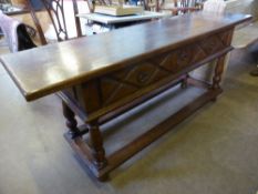 A reproduction oak sideboard having two drawers with diamond pattern to the fronts on turned legs