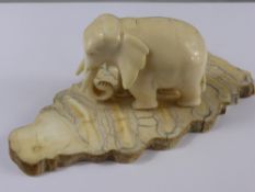 Antique Carved Ivory Elephant, supported on a segmented elephant tooth base, approx 13 x 5.5 cms