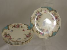 Six pieces of Chelsea porcelain comprising a cake stand and five plates, decorated with flowers and