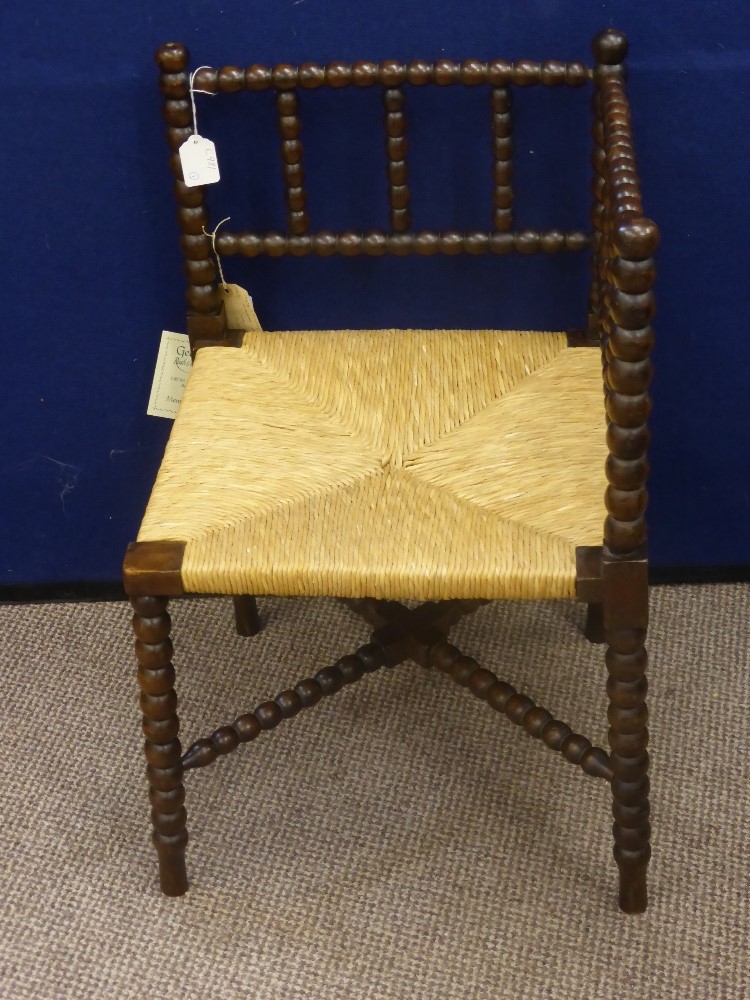 A Vintage Oak Bobbin Carved Corner Chair, the chair benefits from a new rush seat.