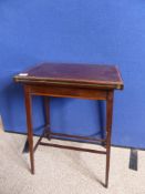 An Edwardian mahogany card table on tapered legs united by stretchers with banded inlay to edge of