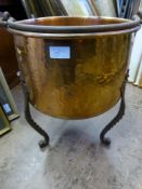 An Antique Hammered Copper Cauldron supported on three turned wrought iron legs 32 x 43 cms.