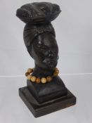 A Wood Carved Bust of an African Woman, depicted balancing a basket of fish on her head, approx 18