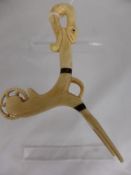 An antique bone pie crimper, in the form of a serpent with horn trim approximately 16 cms long.
