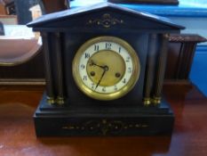 A Victorian slate mantle clock having two corinthian style columns to each side.