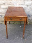 A Regency mahogany drop leaf tea table having inlaid banding to the edge on turned legs and brass
