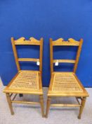 A Pair of Edwardian Bedroom Chairs, with cane seating on turned legs.