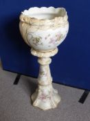 A Victorian ceramic jardiniere and stand, cream ground with pink and green floral decoration, total