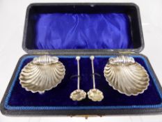 Two Solid Silver Salts, in scallop form with beaded feet and two salt spoons, presented in the