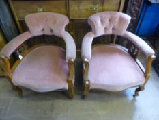 A pair of Victorian tub shaped mahogany button back armchairs on shaped legs and brass castors, the