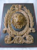 A Limed Decorative Lion Mask Carving, mounted on an olive green panel, approx 63 x 48 cms.