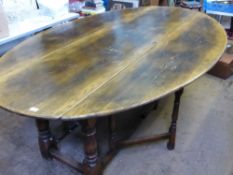 A large 16th century style American oak drop leaf dining table being oval in shape on part turned