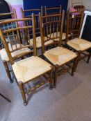 A Set of Six Edwardian Dining Chairs with turned spindle back support and rush seating.