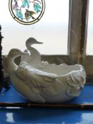 An Italian white ceramic jardiniere in the form of two swans, also having foliate decoration,