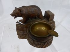 A Black Forest carved ashtray, the carving depicting a prowling bear.