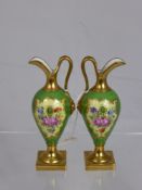 A Pair of Continental Gilded Miniature Ewers, hand painted with floral spray, approx 12 cms.