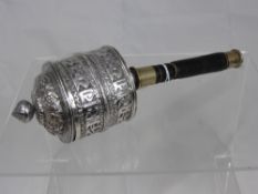 A silver metal antique Sino Tibetan prayer wheel having floral decoration to the top with figured