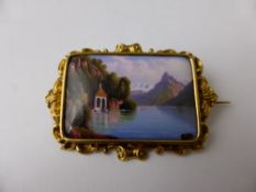 An Antique Hand Painted Porcelain Brooch depicting a tranquil lake scene, the brooch set in a