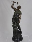 A Spelter figure of a blacksmith depicted with hammer and anvil on an ebonised plinth,