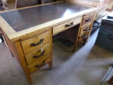 An Edwardian oak desk having a brown leather insert to top, three drawers and a slide to each side