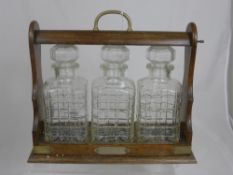 An Oak Tantalus with three cut glass decanters.