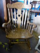 An American `Amish` Oak Rocking Chair, with floral decorative carving to the head rest, with a