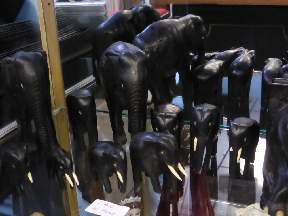 A collection of hand carved elephants being of hard wood together with a silver metal photo frame