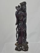 An Antique Chinese Hand Carved Red Amber Figure of Guaylim sitting on a hand carved wood base