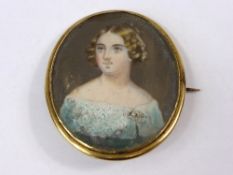 A hand painted miniature circa 1820 of a lady set in a yellow metal frame with pin brooch to back,