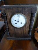 French table clock, being oak cased with an enamel dial and pillar support.