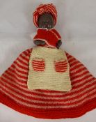 Vintage coloured tea cosy in the form of a doll.