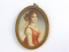A fine quality hand painted miniature on ivory depicting a lady in brass mount
