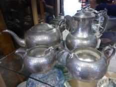 Hammered English Pewter Tea Set comprising milk jug, sugar bowl, tea pot, coffee pot. (4)