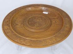 Vintage carved round wooden platter depicting a farm girl with corn, the platter having a hand