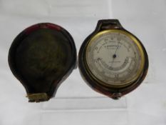 A miniature barometer by M Aronberg & Co. Liverpool, in a leather case, approx. diameter of