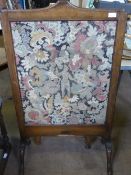 Vintage mahogany framed fire screen, the embroidery depicting a young man amidst a foliate