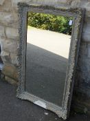 Bevelled glass wall mirror in a gilt wood frame decorated with flowers on a black background,