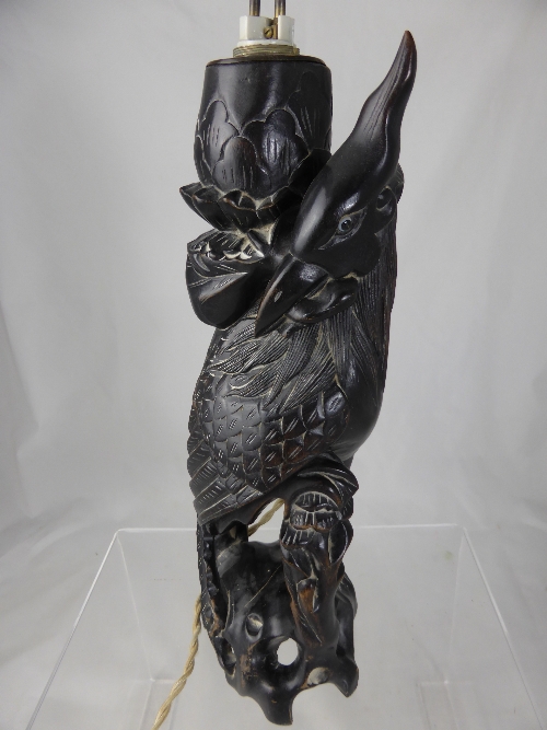 An antique Chinese carved figure of a bird, the bird having glass eyes, 35 cms h.