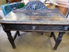 Ebonised oak Jacobean style hall table, the top having an arched top to the back decorated with a