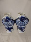 A pair of antique blue and white Delft segmented vases, the vases depicting flowers and village