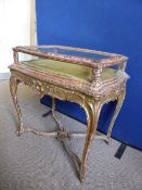 A French bijouterie table in the Rococo style, glass panels on four sides, cabriole legs with an x-