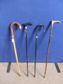 An Four silver collared walking canes, two ebonized.