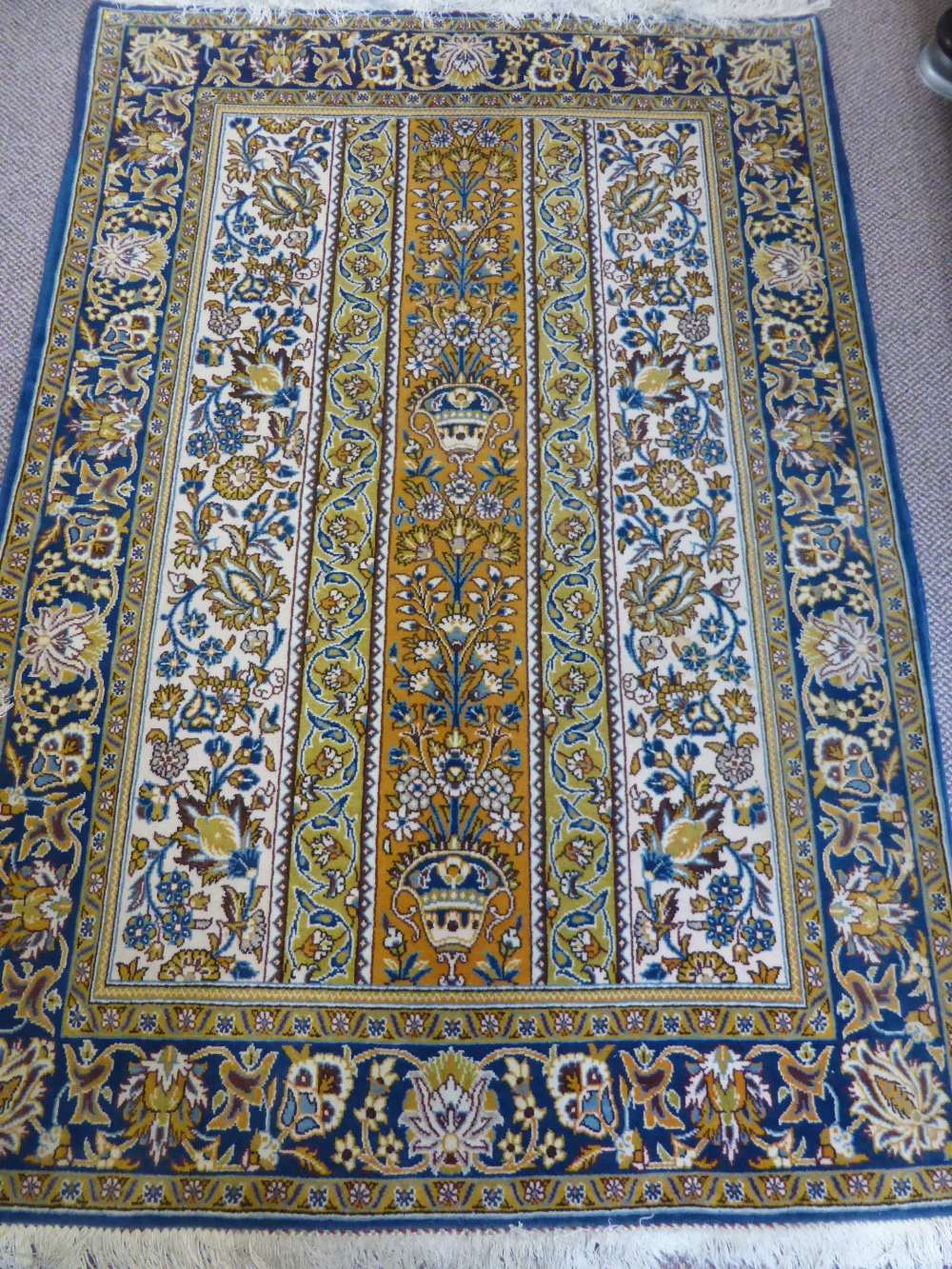 A Persian Carpet, with blue and gold floral design on cream ground, decorative urn design to the