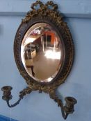 A Regency style wall mirror with two candle sconces, with decorative ribbon to the top and laurel
