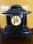 A Victorian Slate Mantle Clock in a neo-classical style with Corinthian columns to either side,