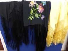 Three Victorian hand embroidered shawls, one yellow and two black.