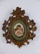 Hand painted Miniature on Porcelain, depicting a cherub, in a fine Black Forest Frame.