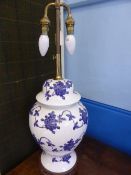 Two table lamps, one being brass and porcelain in the form of a Chinese lidded pot on a wooden base