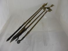 A set of brass fire irons including tongs, coal shuttle and poker.